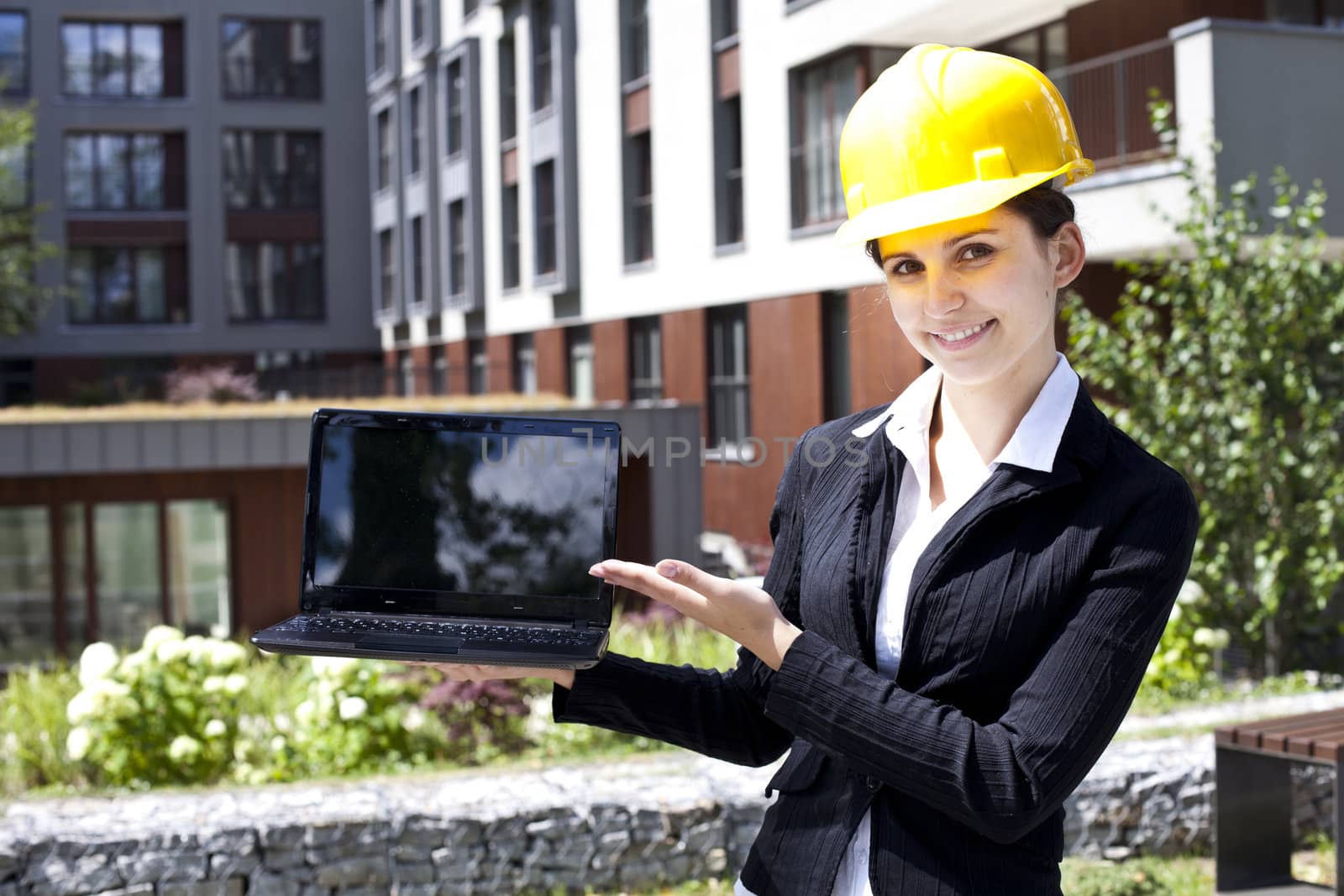 Female construction engineer show something on laptop