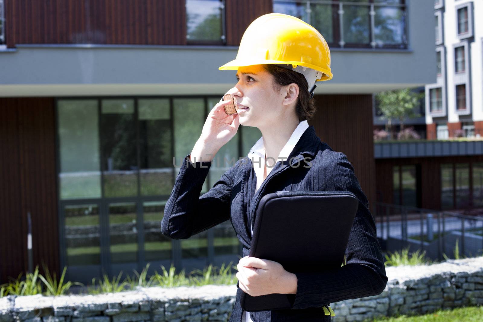 Young female construction engineer with phone