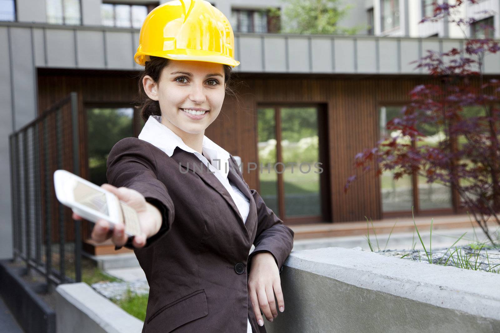 Young female construction engineer with phone by fikmik