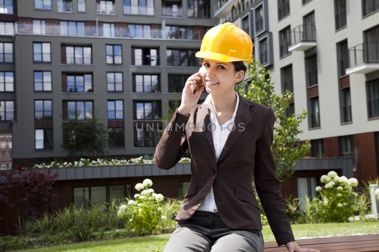 Young female construction engineer with phone by fikmik