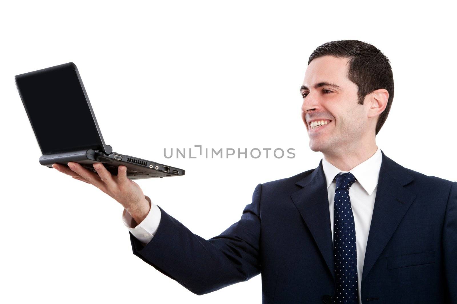 Handsome young business man in blue suit raising a laptop.Isolated on white.