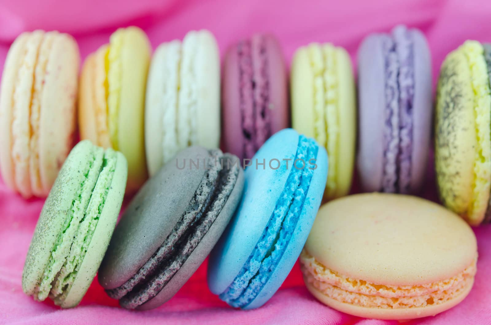 close up colorful  french macaroons   on  pink fabric