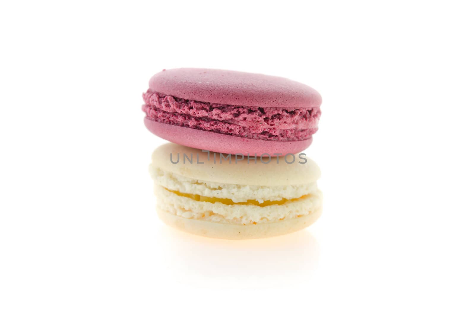 french macaroons in pink and cream stack on  white background