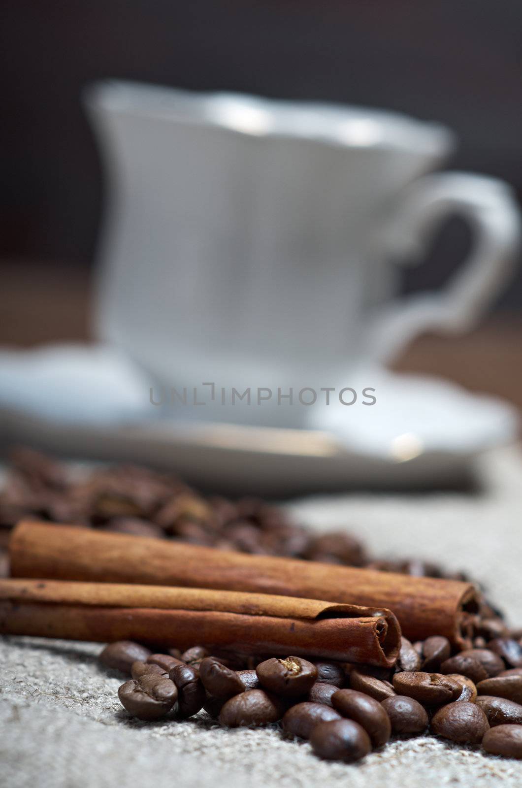 Coffee cup with cinnamon and coffee beans background