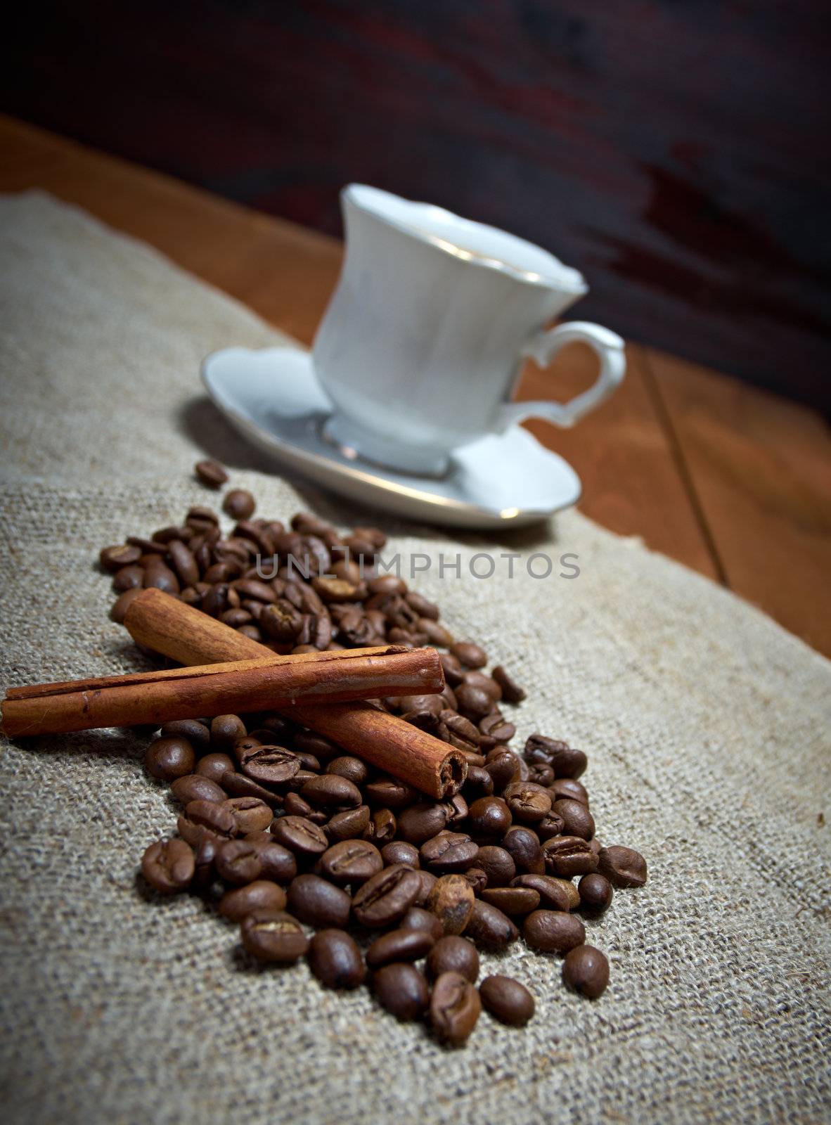 Coffee cup with cinnamon and coffee beans background