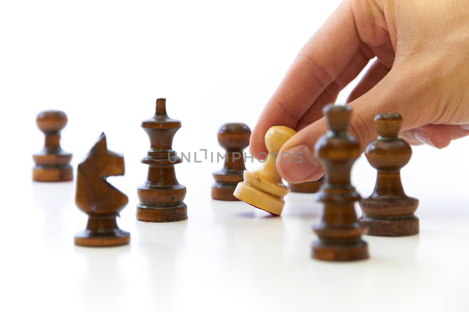 Hand taking chess piece pawn on white background