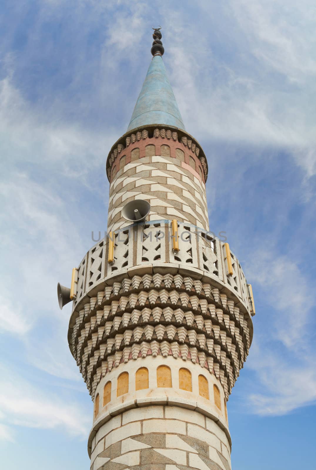 Minaret and blue, clear, cloudy sky.