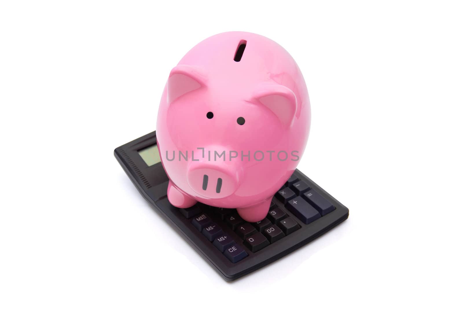 Pink piggy bank is on the calculator on white background.