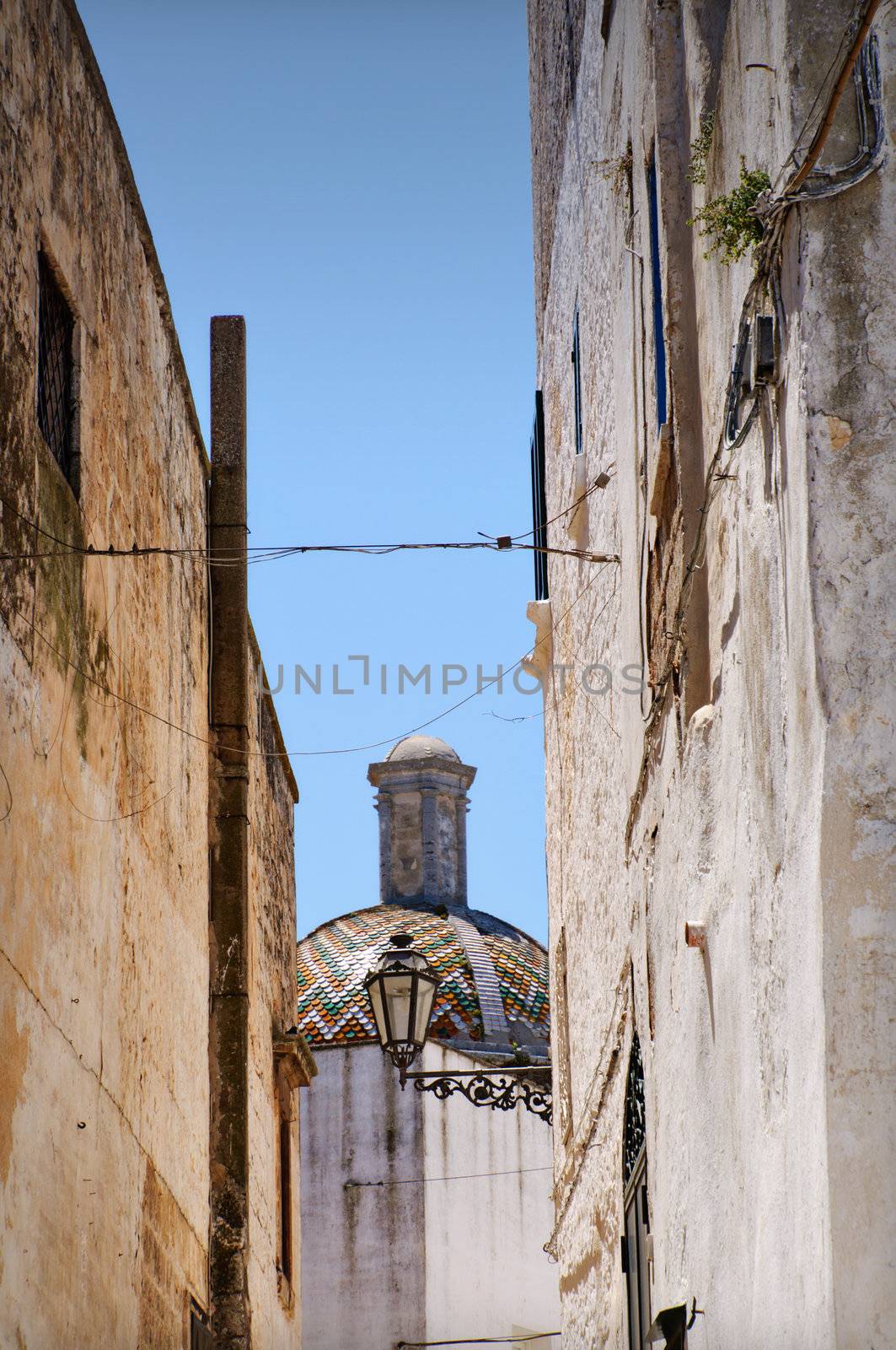 Ostuni lane in the Old Town (the White City) with a dome in the background, Puglia, Italy