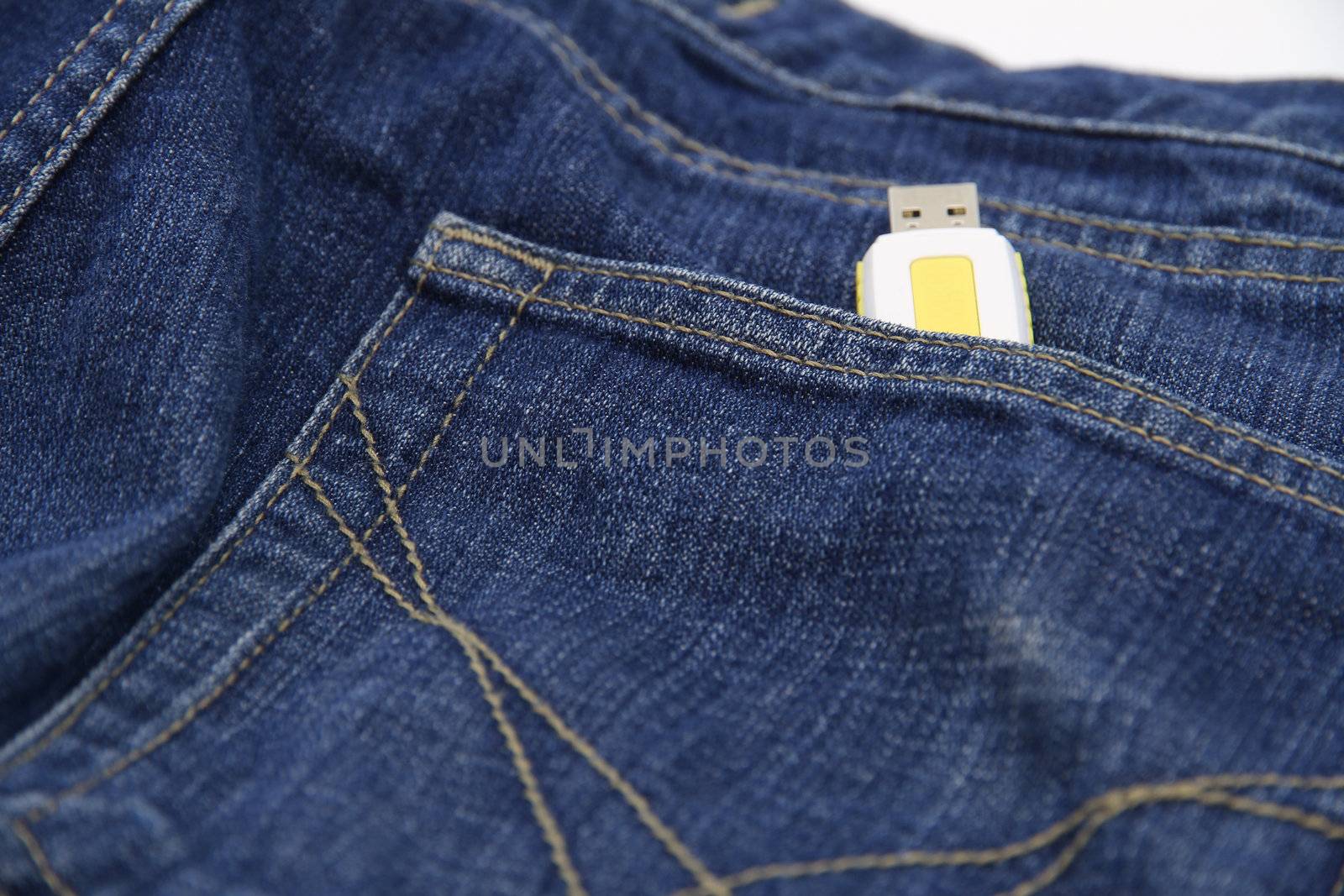 Yellow USB drive in the pocket of jeans