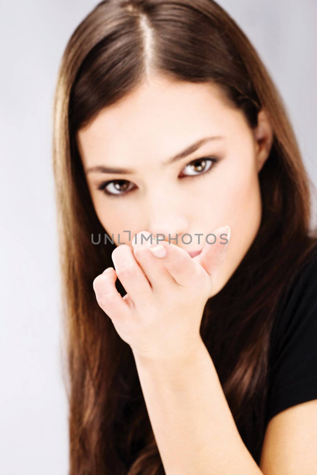 Young woman holding contact lens on finger in front of her face