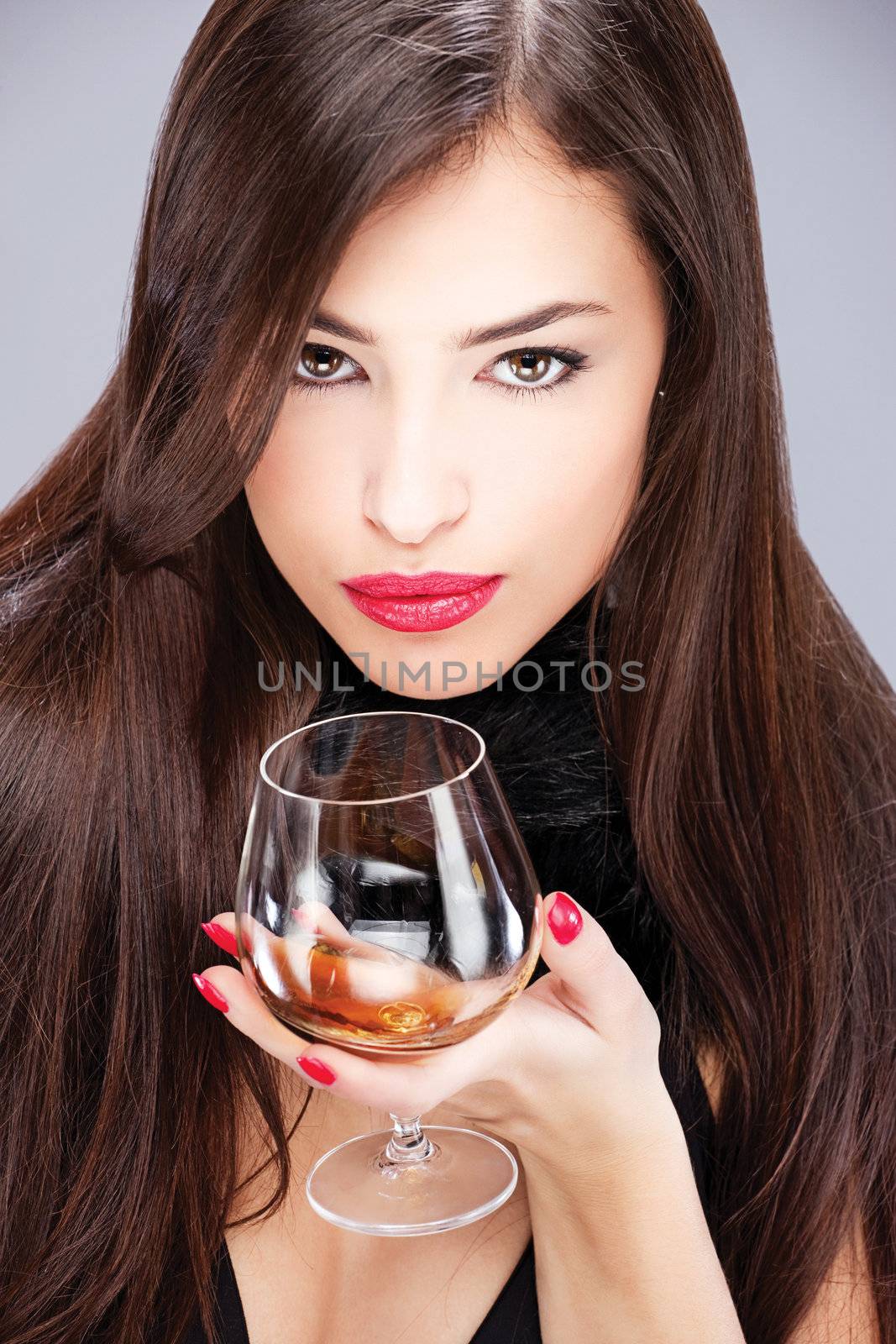  woman with pelt holding glass of brandy by imarin