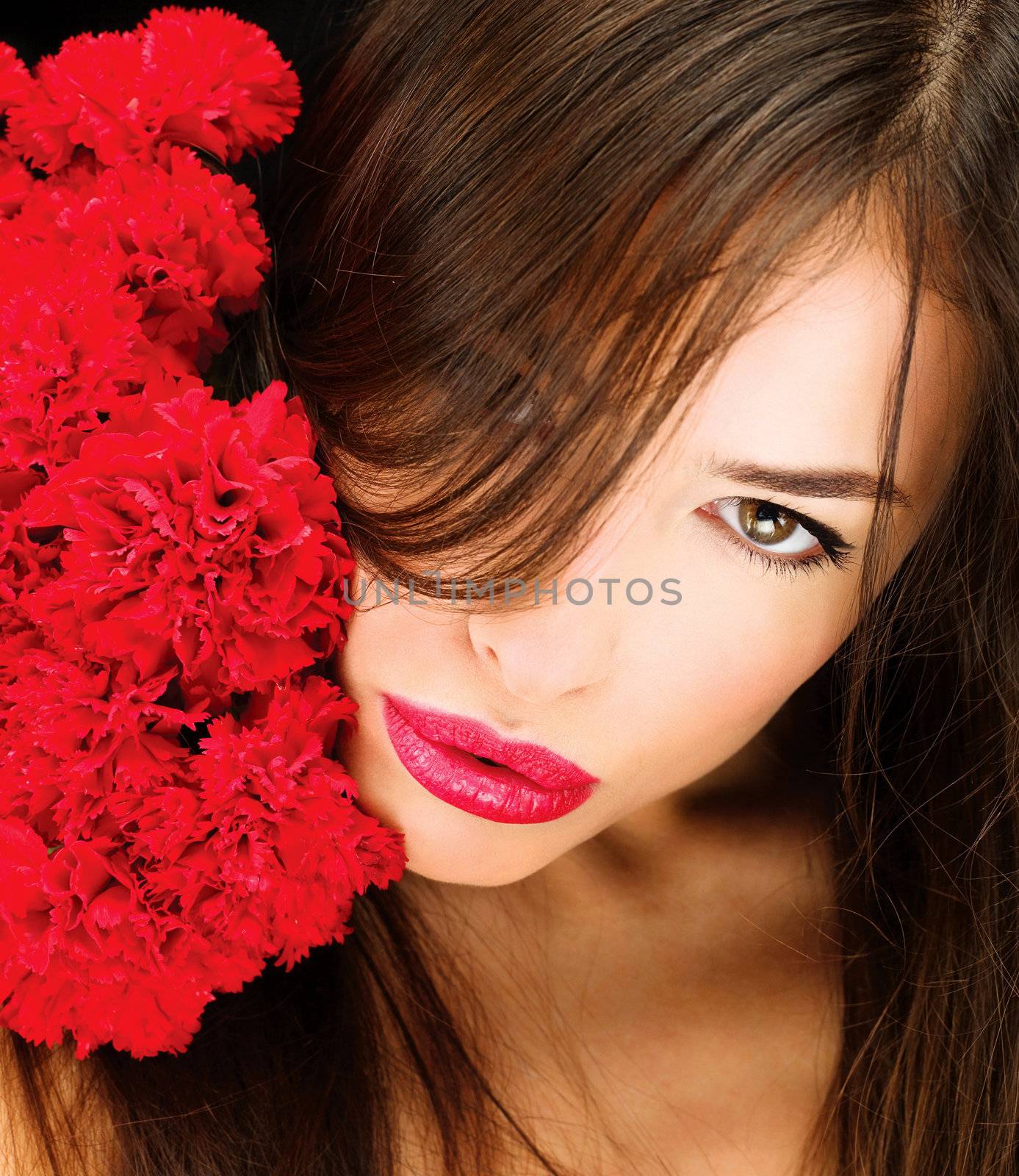 Pretty woman and bouquet of a red carnations on her shoulder