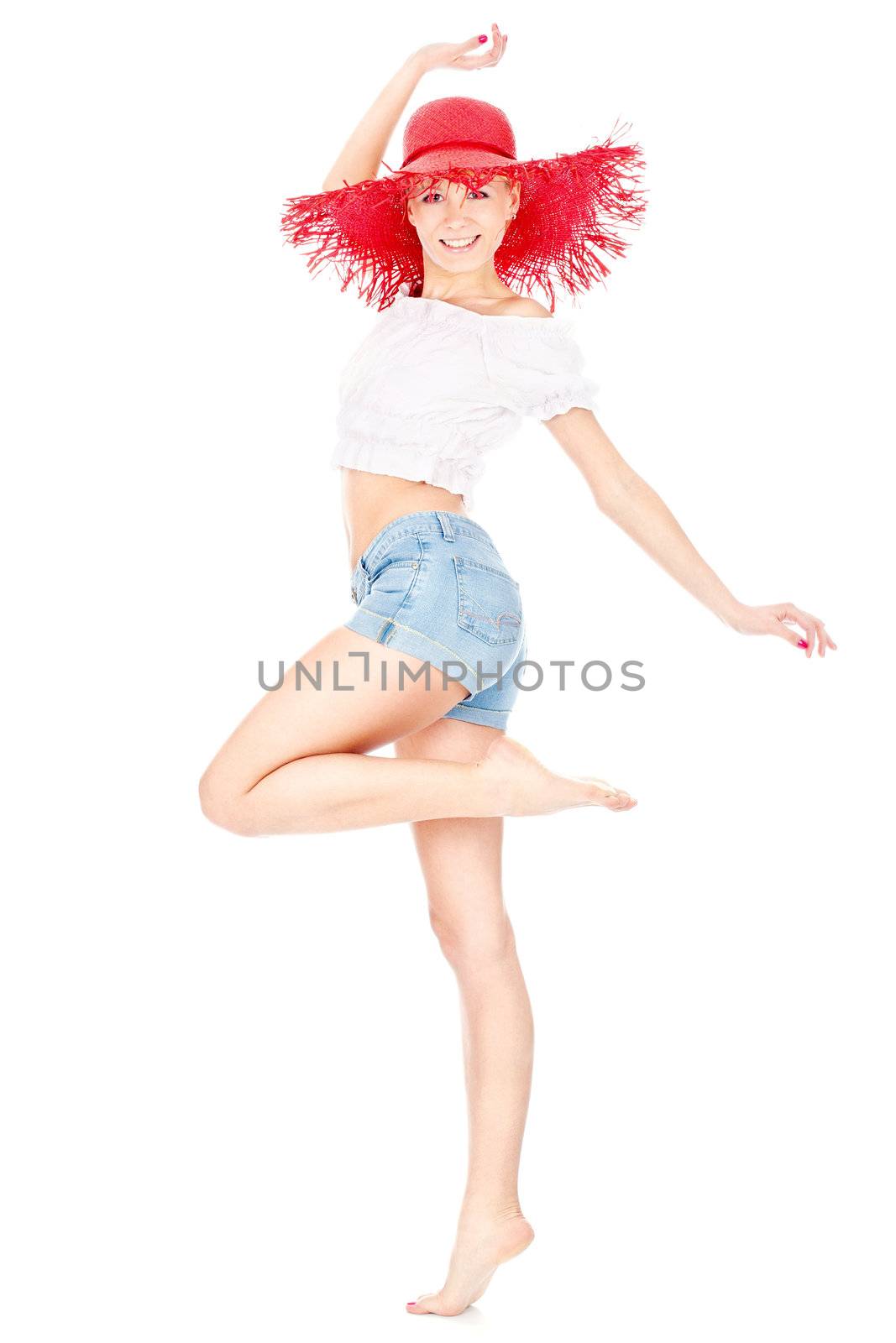 Happy young woman with big red hat barefoot dancing, isolated on white background
