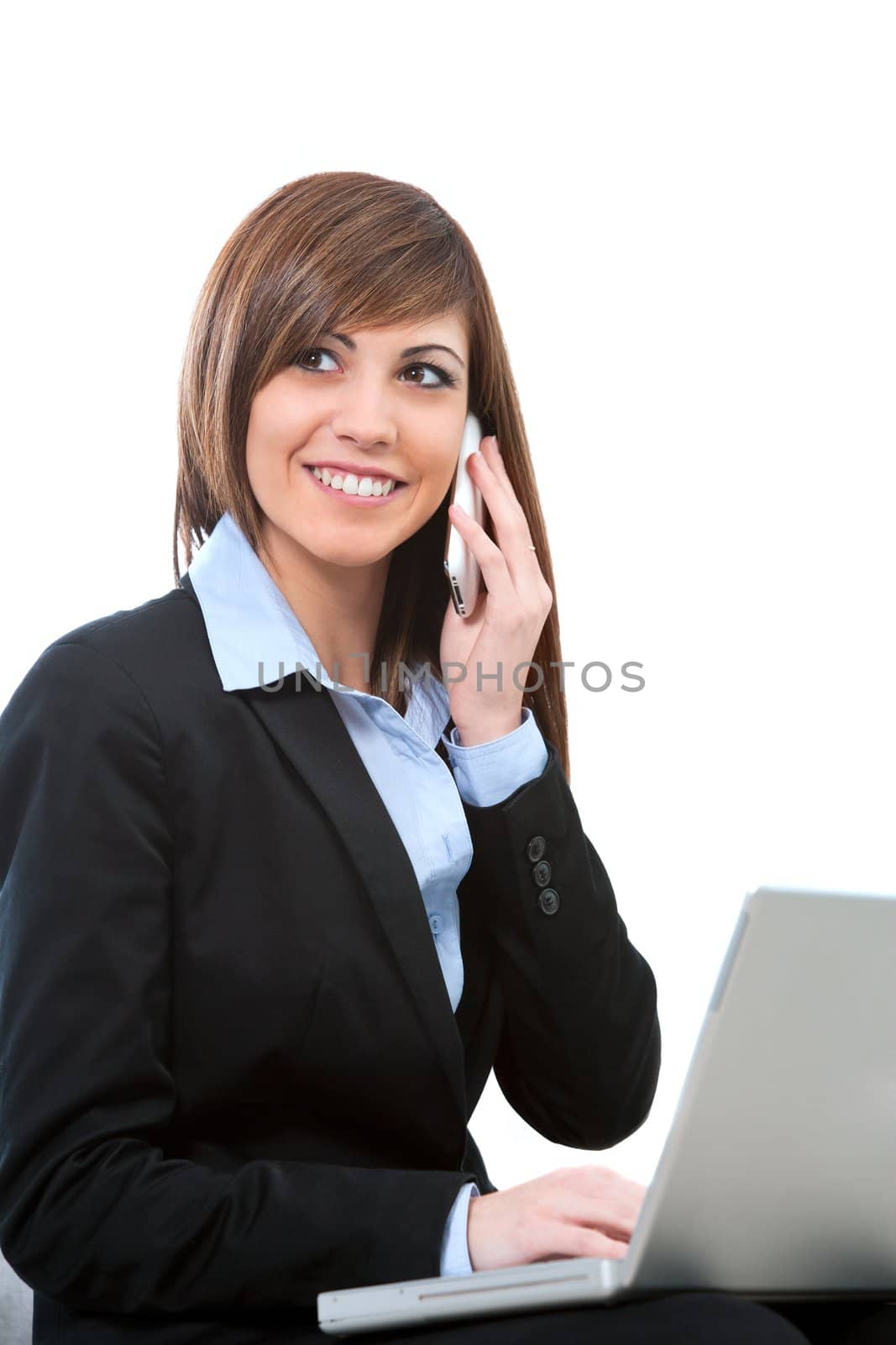 Attractive young business woman talking on cell phone with laptop. Isolated on white.