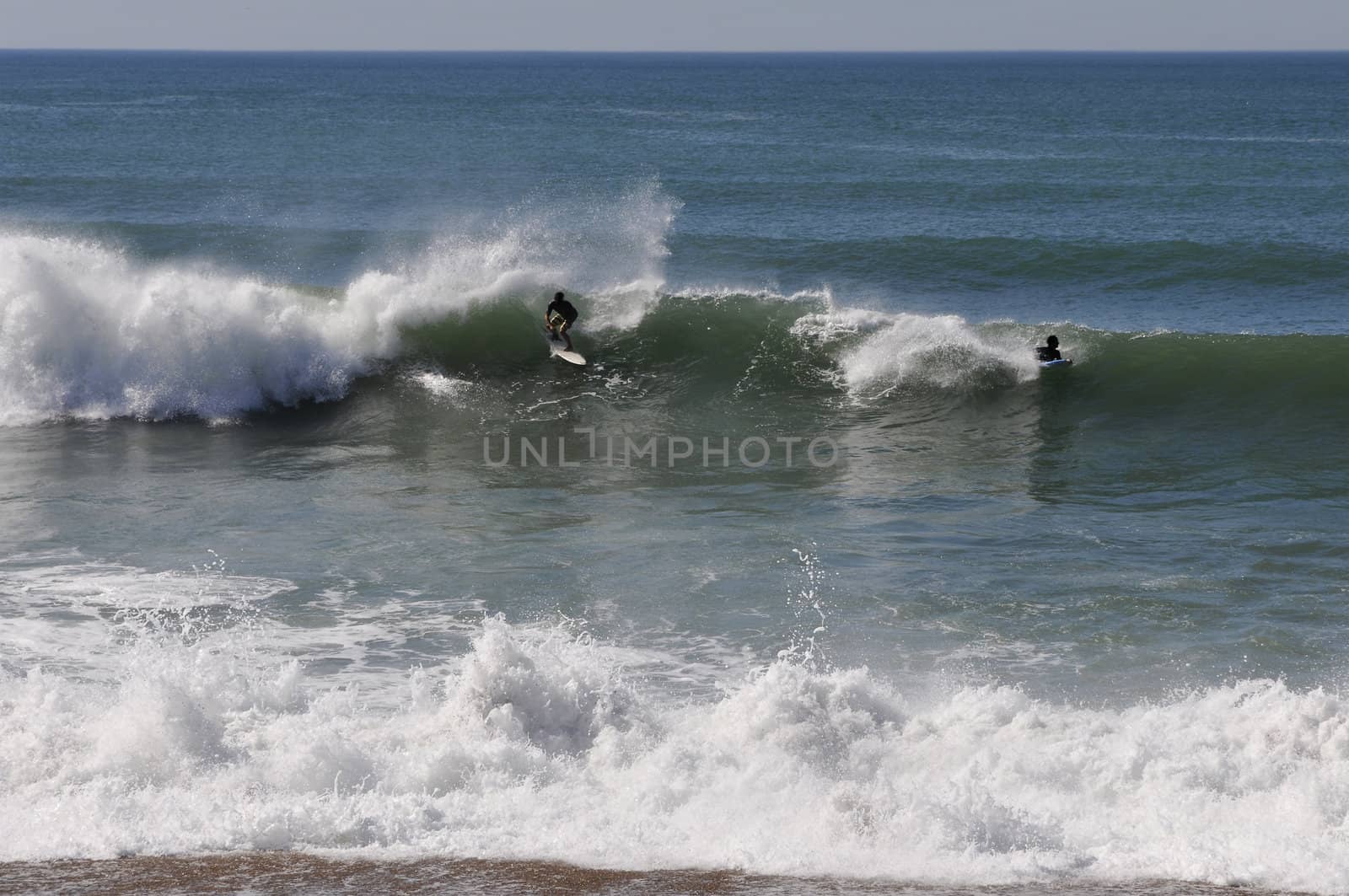Two surfers on a wave during a nice day