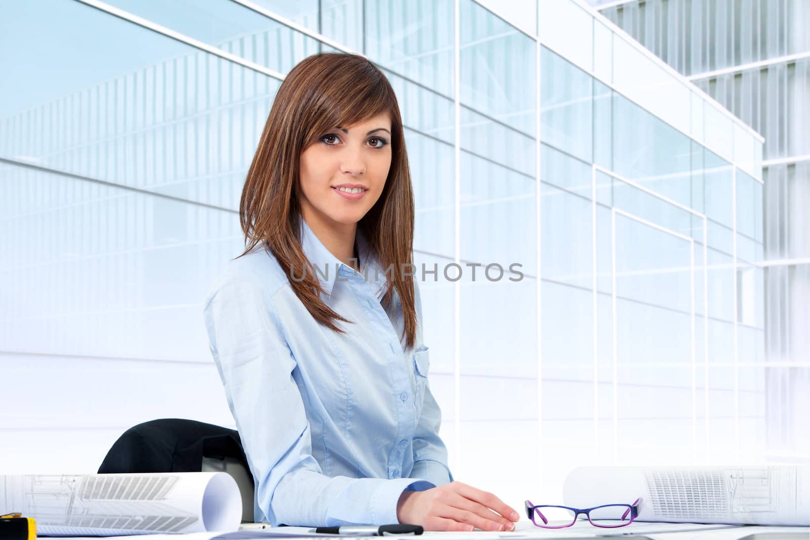 Portrait of female office worker at desk. by karelnoppe