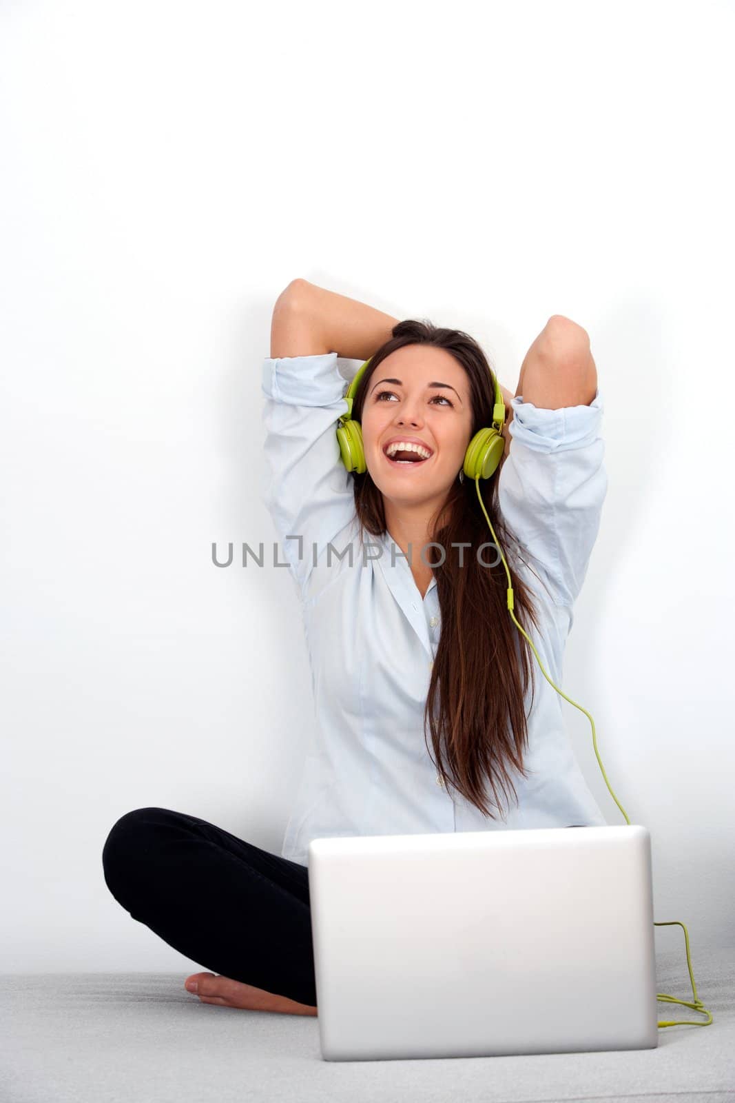 Happy young woman with laptop and earphones by karelnoppe