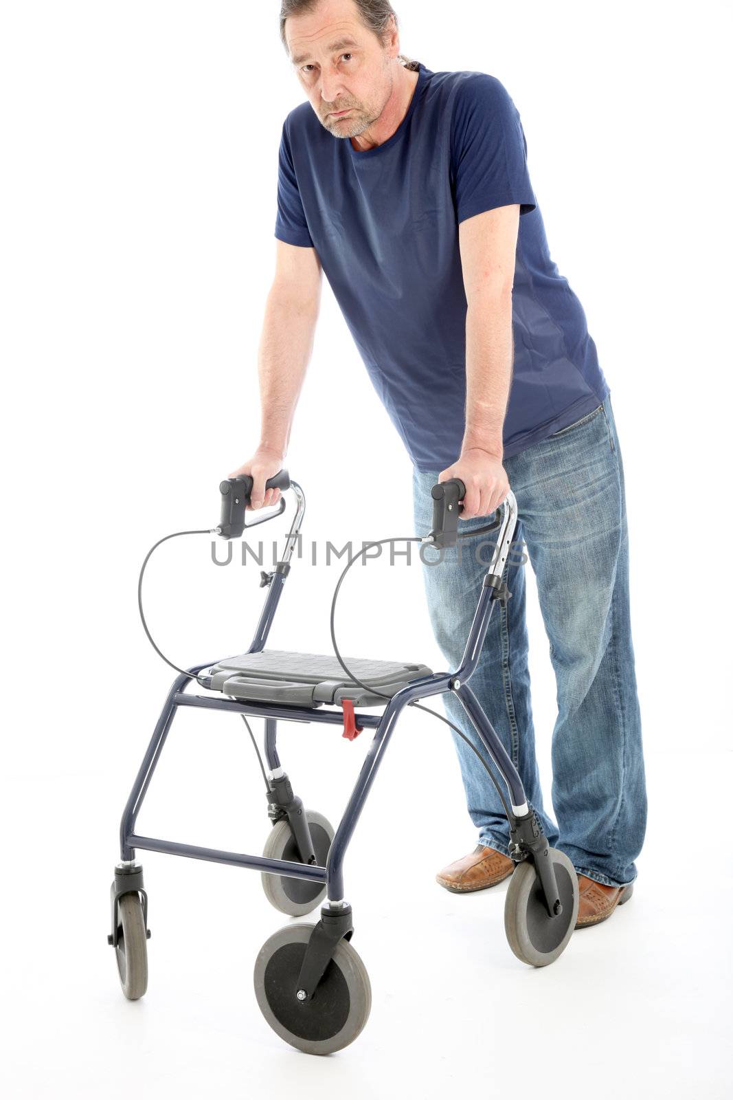 Despondent man facing the camera leaning heavily on a medical walker for support isolated on white Depressed man facing the camera leaning heavily on a medical walker for support isolated on white 