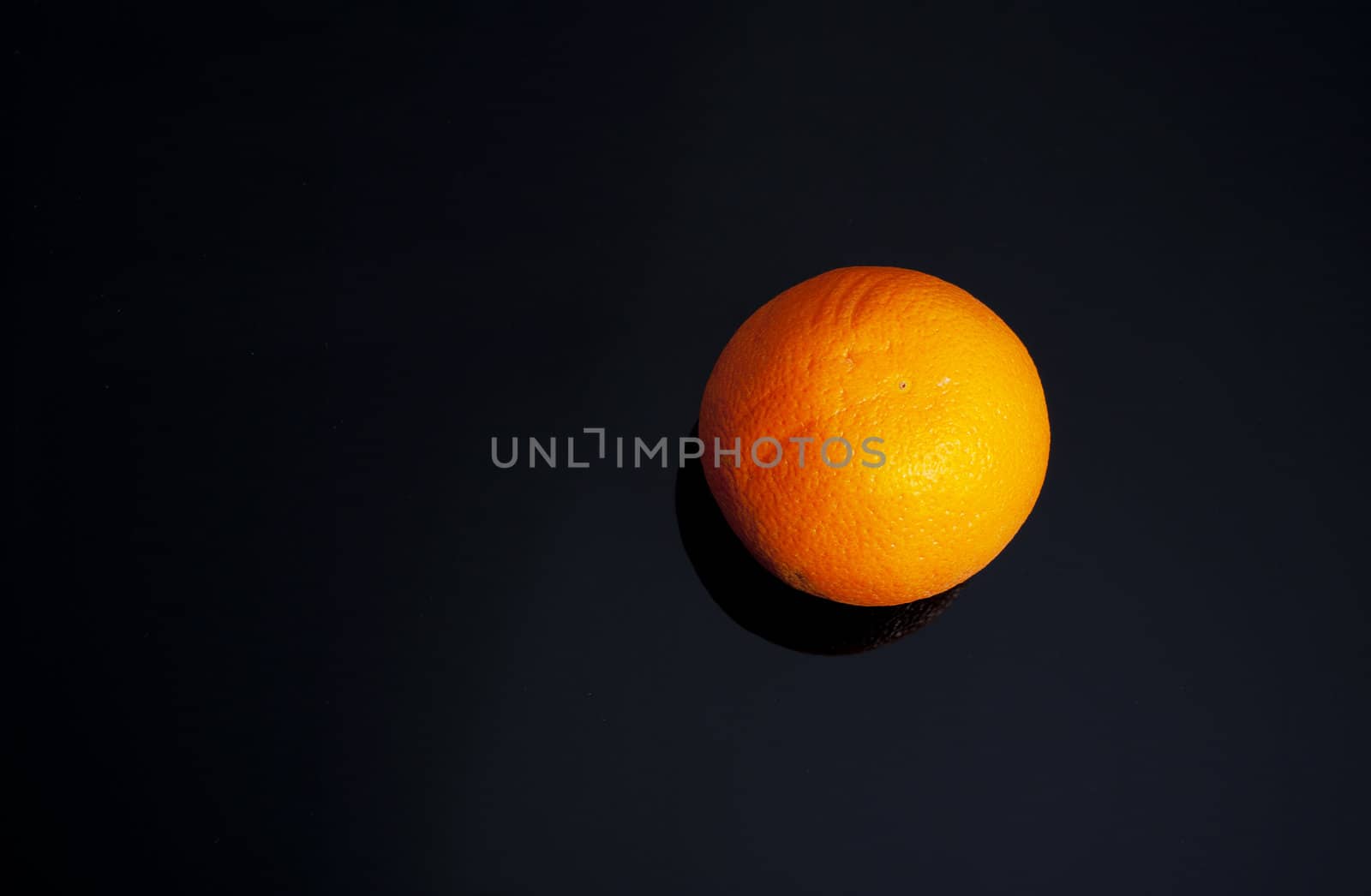 The whole ripe fruit of orange on glass