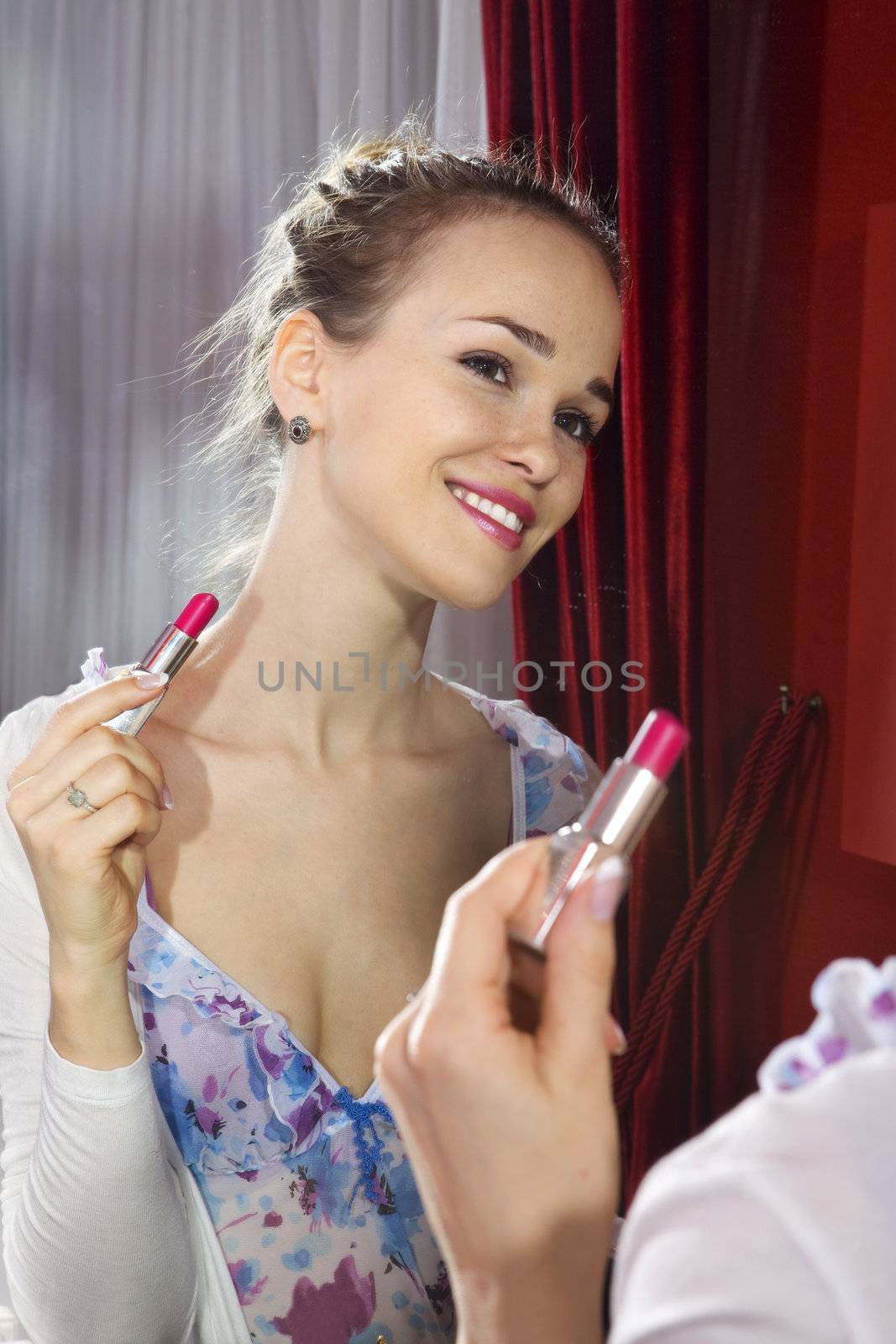 woman applying her make-up by ssuaphoto