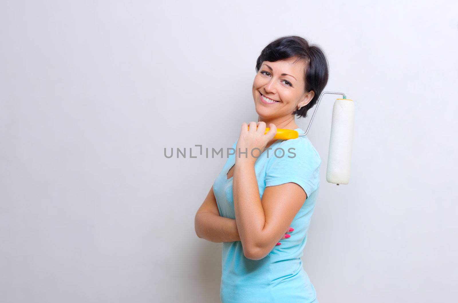 Young smiling woman with painting roller