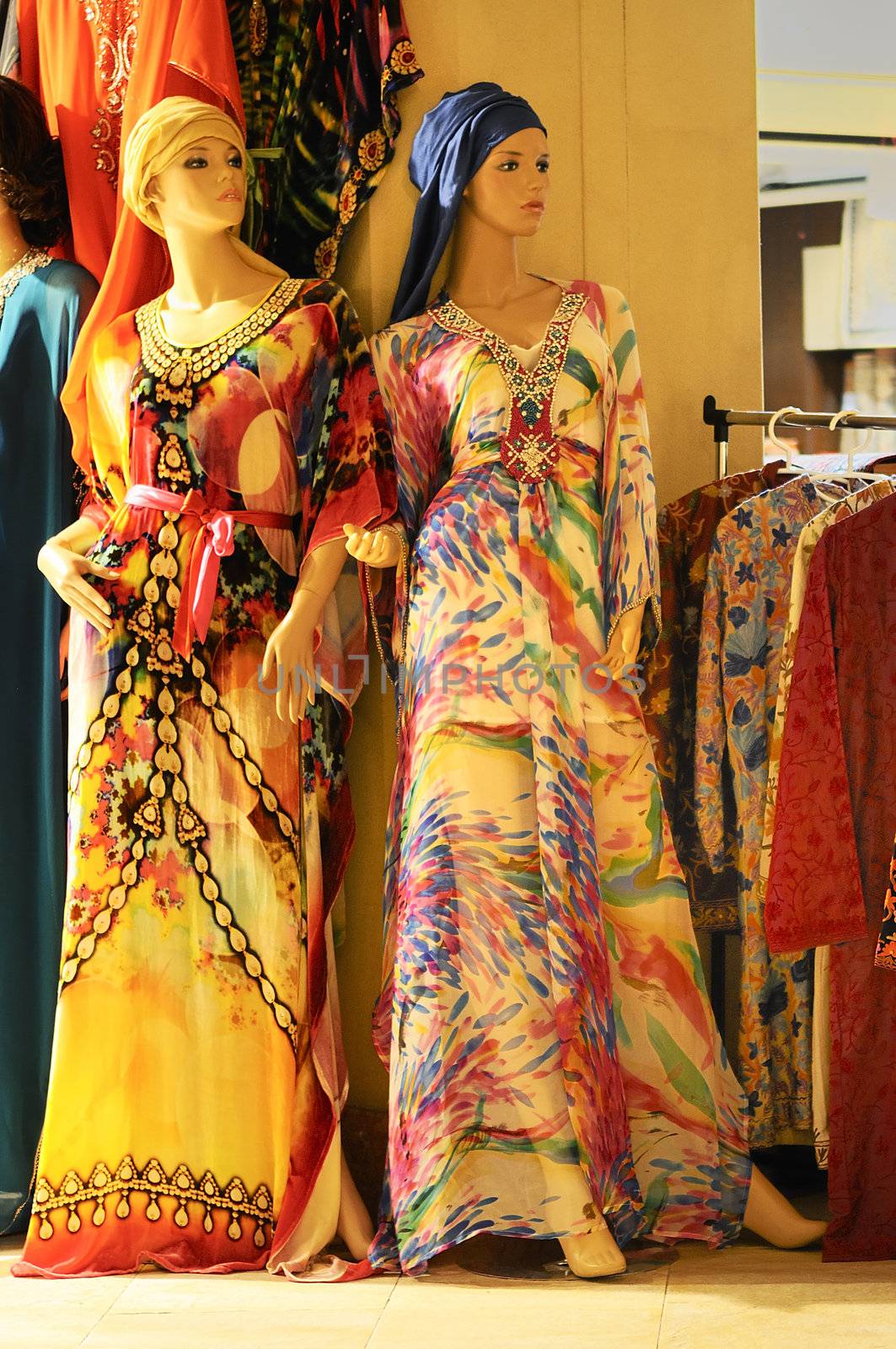 Mannequins in clothes shop with oriental and colored dresses