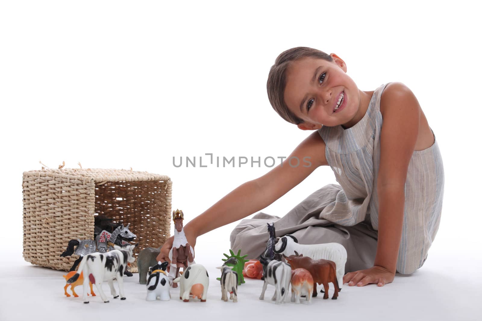 Little girl playing with farm animal toys by phovoir