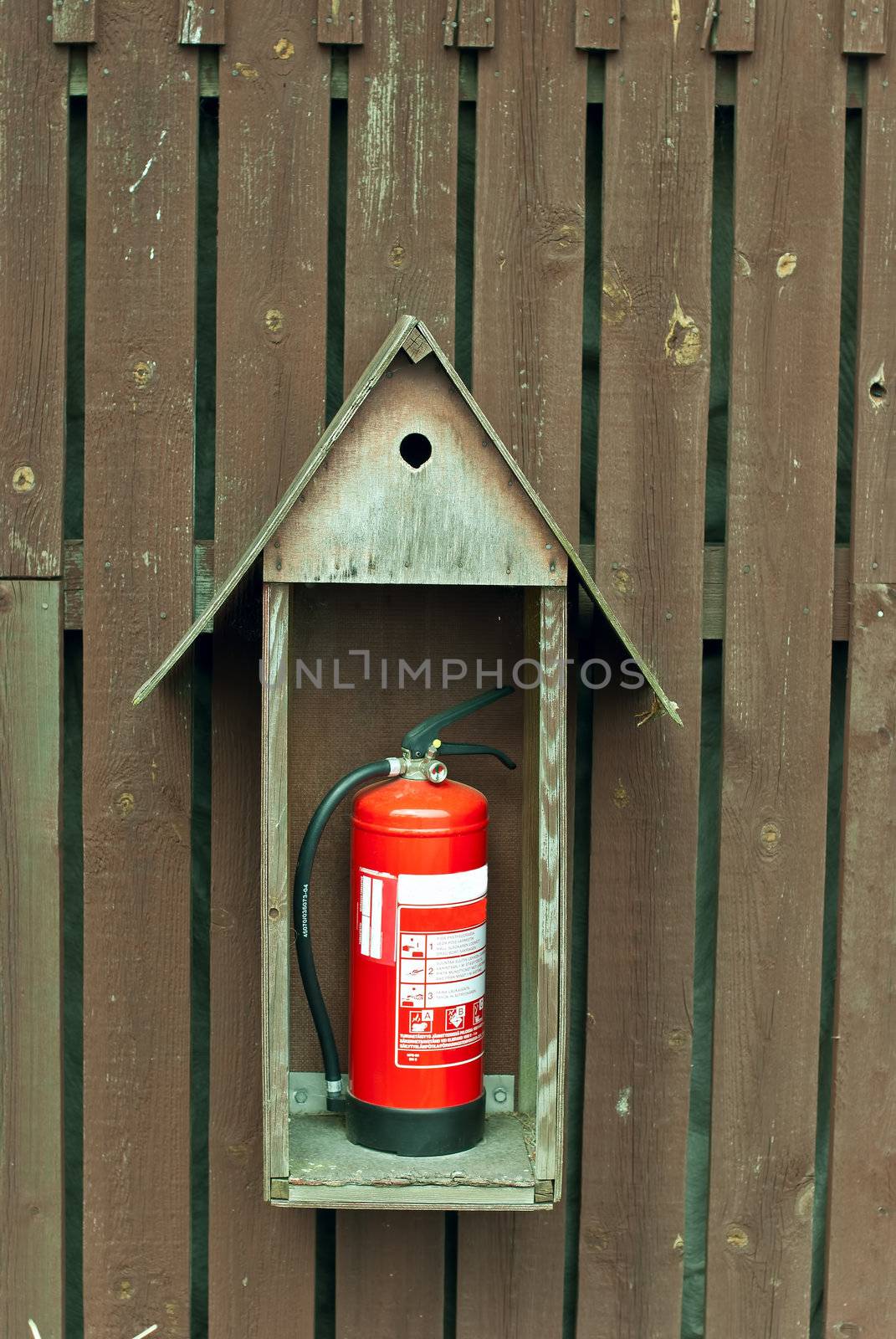 a fire extinguisher on the wall of a wooden shed