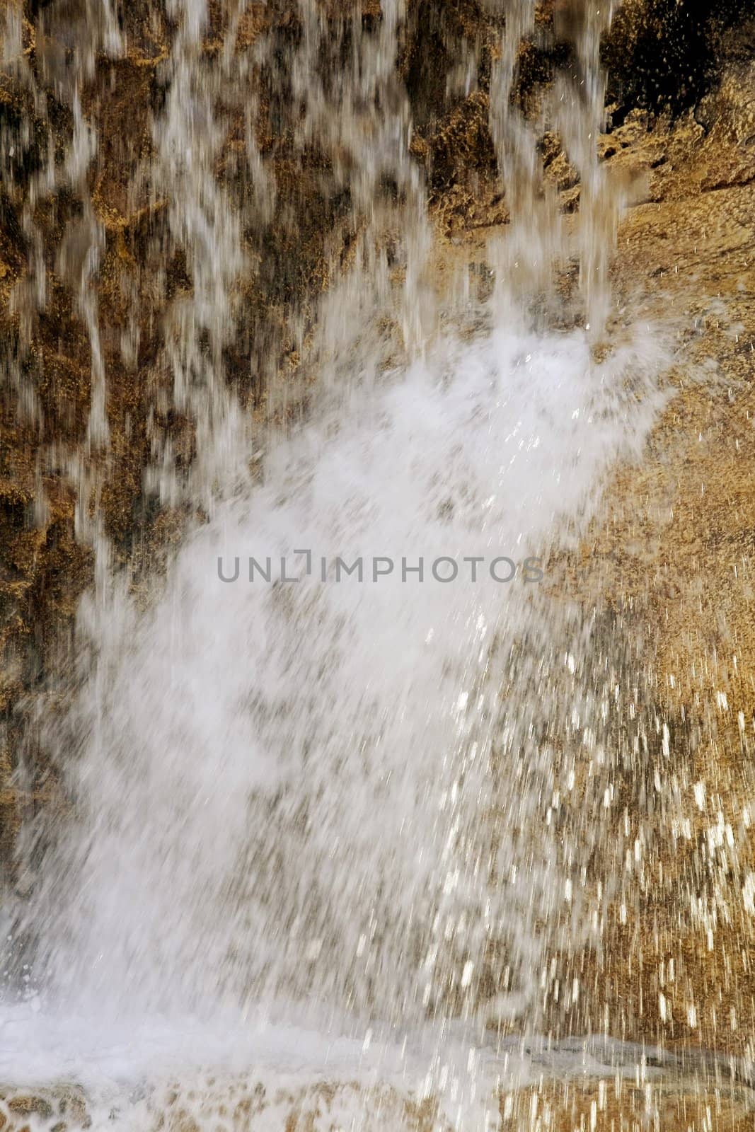 The flow of water falls with solar flares falling from a rock