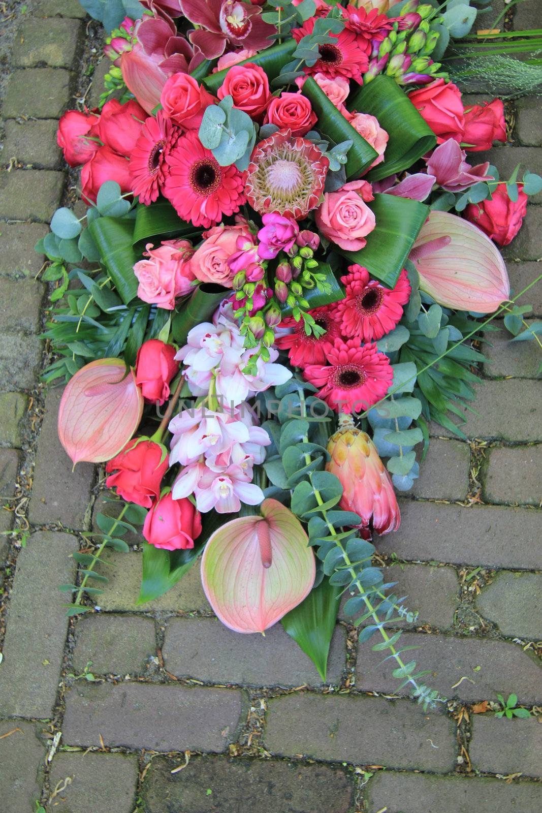 pink sympathy bouquet on pavement by studioportosabbia