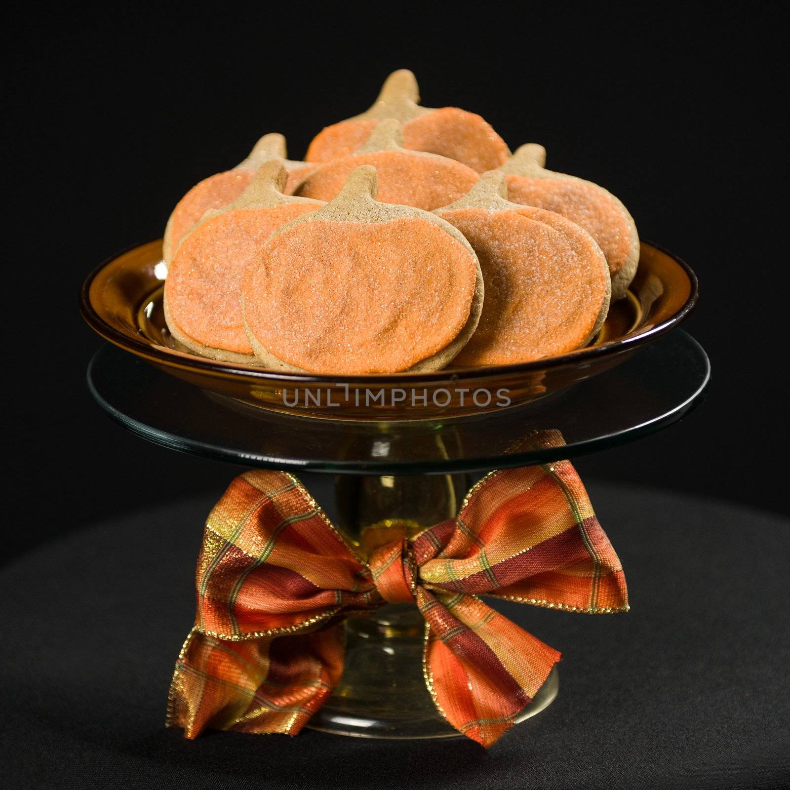 Homemade pumkin cookies on isolated black background.