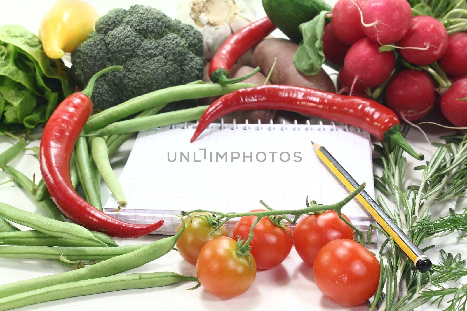 plaid shopping list with fresh vegetables and pencil on a wooden background