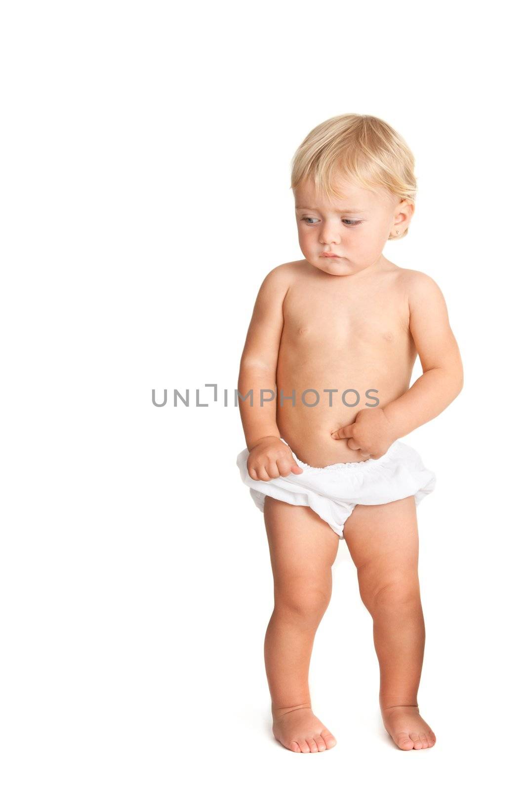 Portrait of full length baby girl with odd face expression pointing with hand on tummy. Isolated on white background.