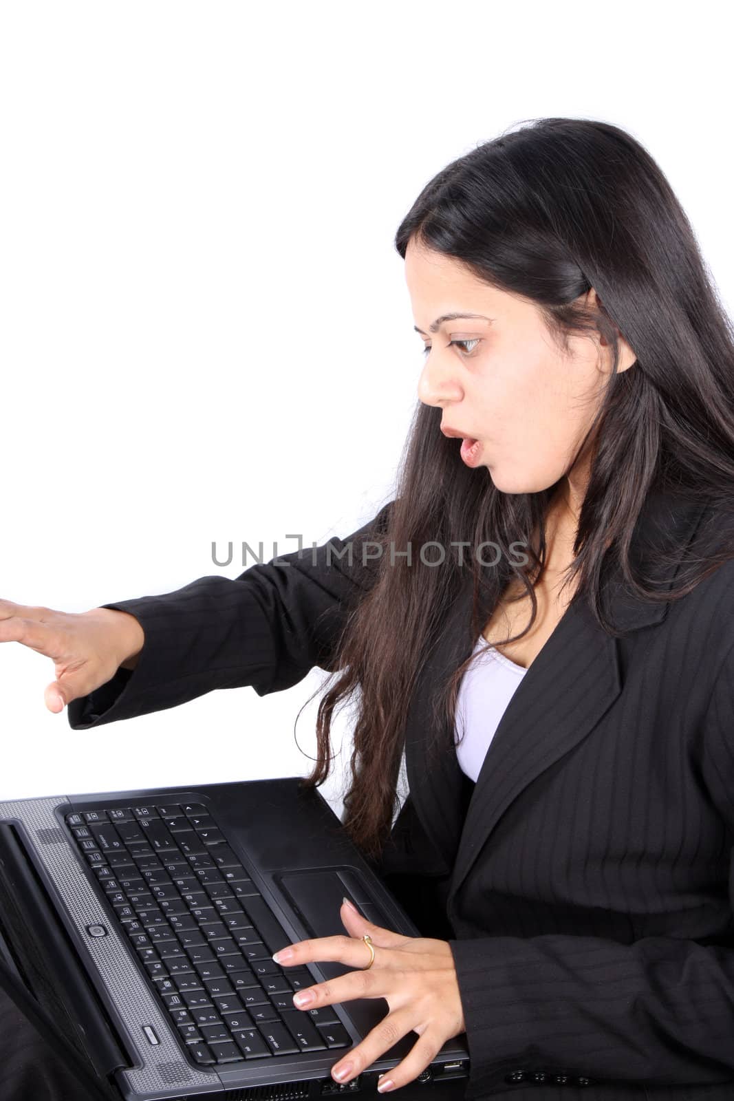 A young Indian businesswoman busy on her laptop, on white studio background.