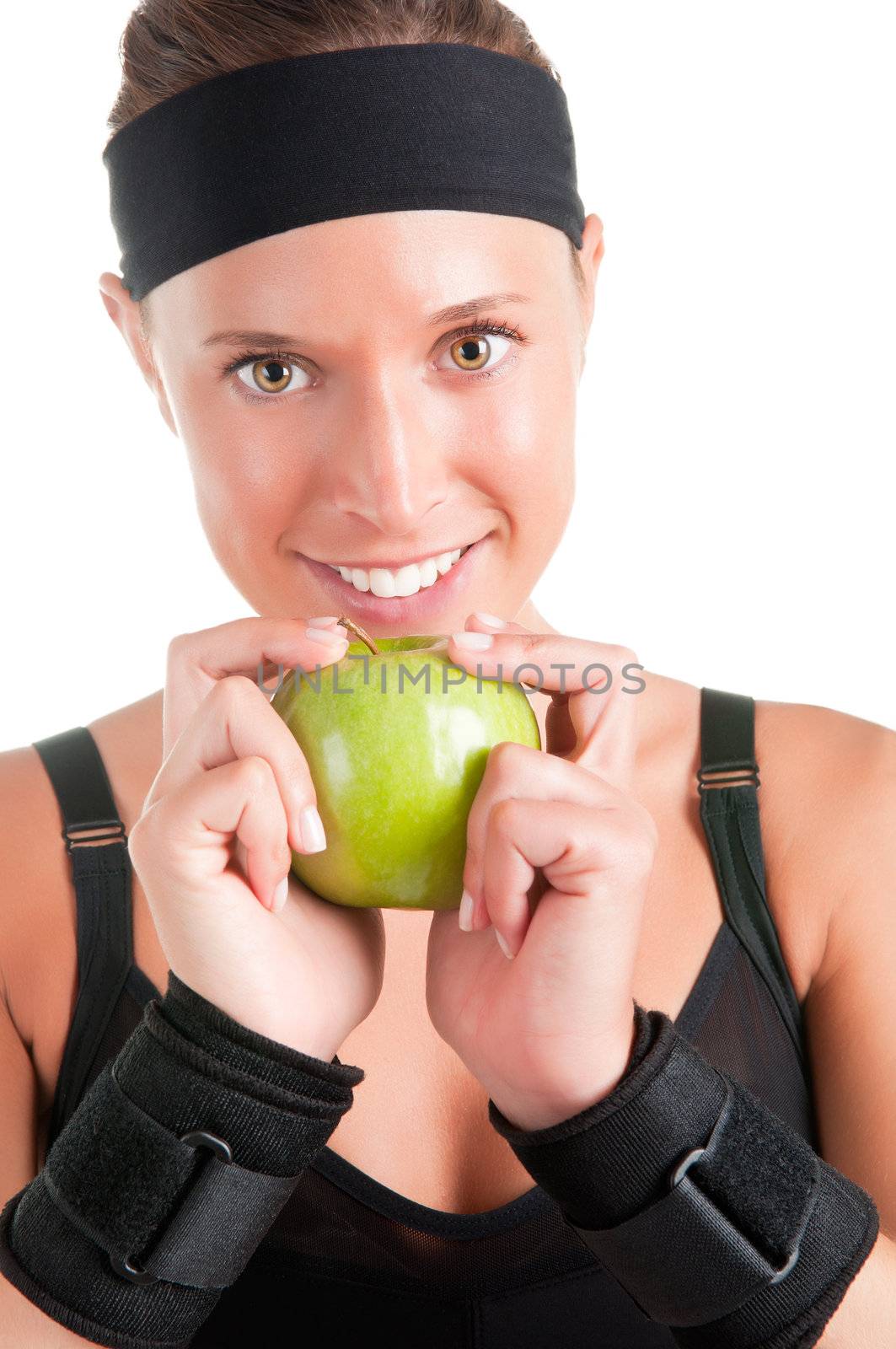 Woman about to eat a green apple after her workout at the gym