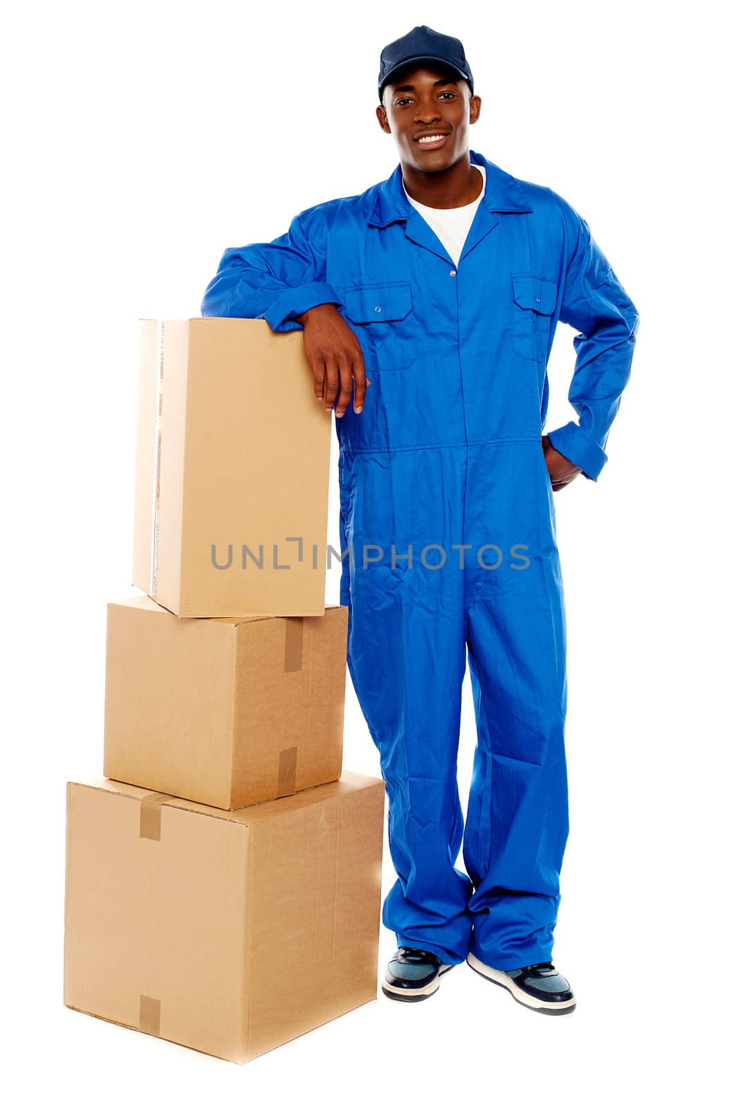 Courier boy standing beside boxes against white background, resting hand on them