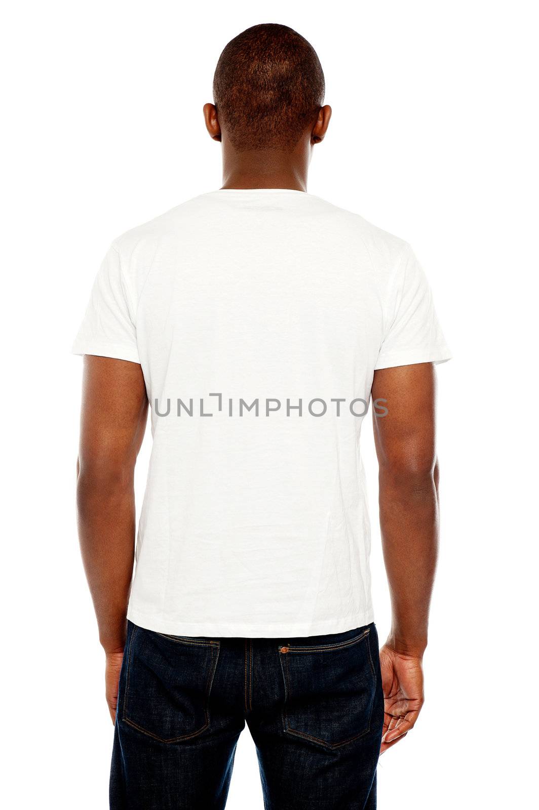 Rear view of casual young guy looking at white wall