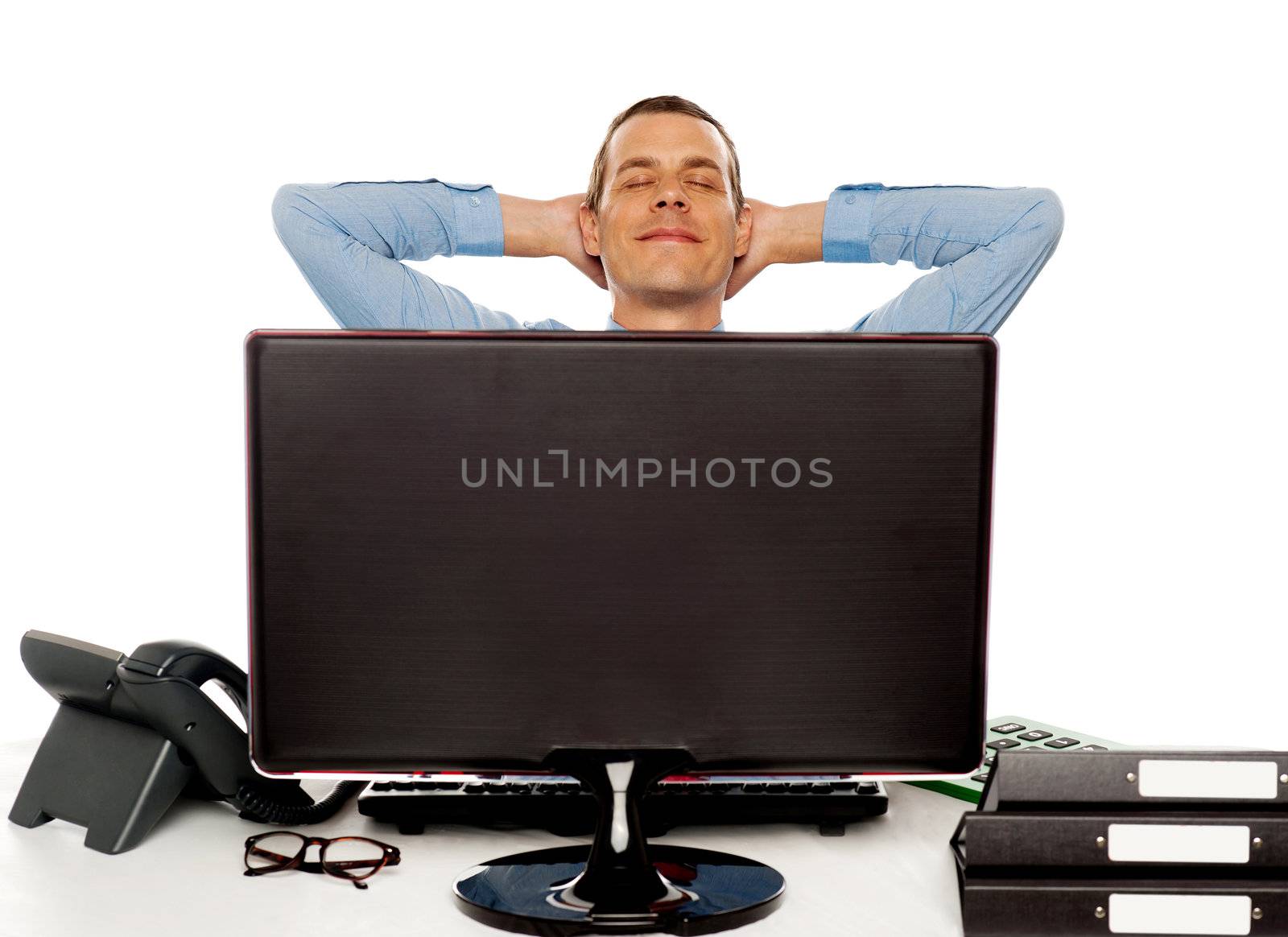 Young businessman posing in a relaxed manner with hands behind head