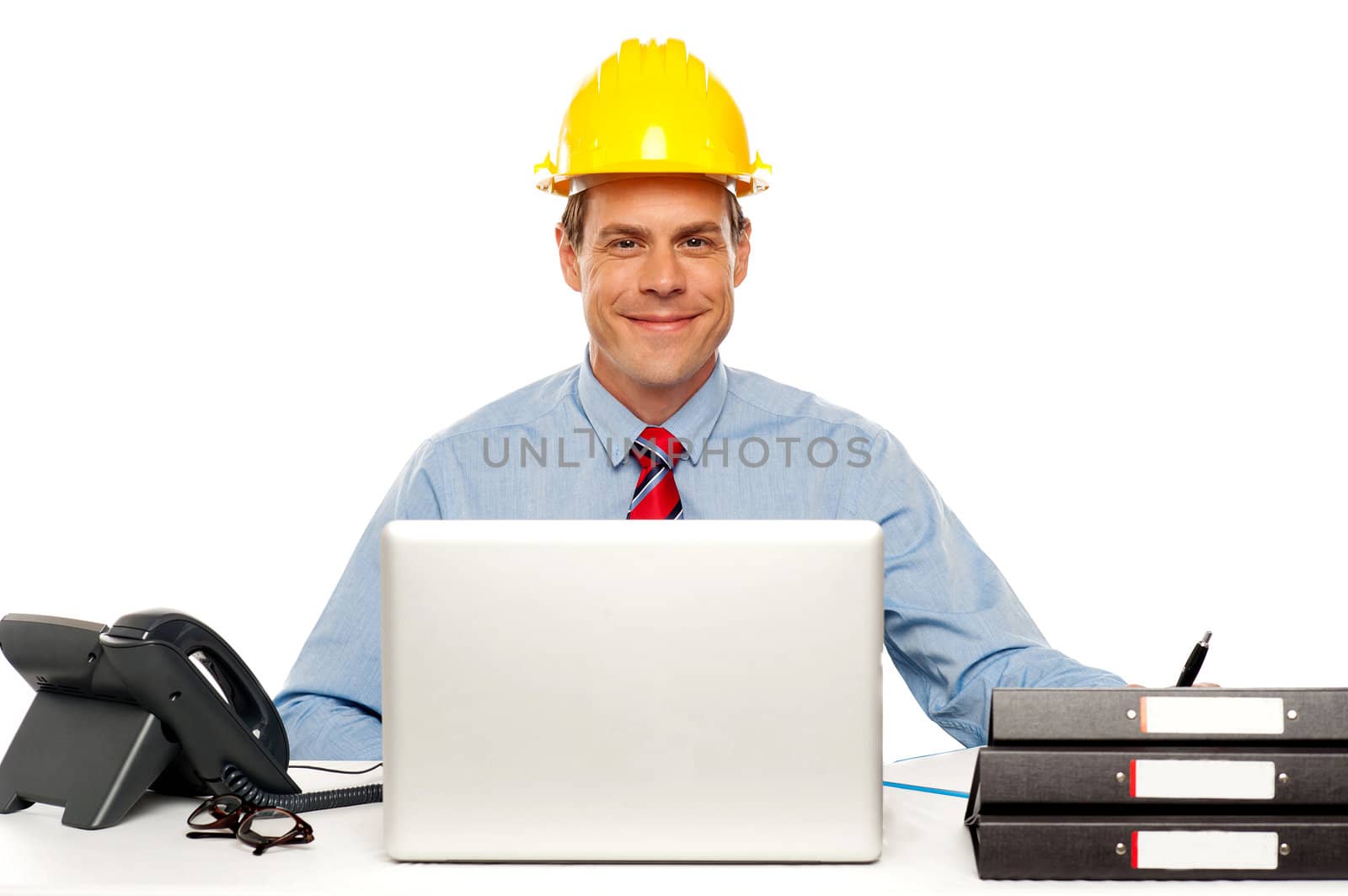 Architect wearing safety hat and using laptop in office. Studio shot
