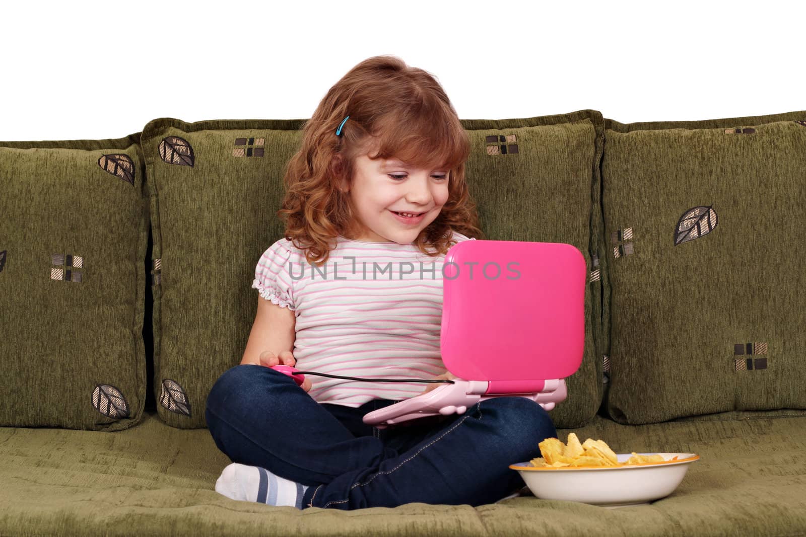 little girl sitting on bed with laptop