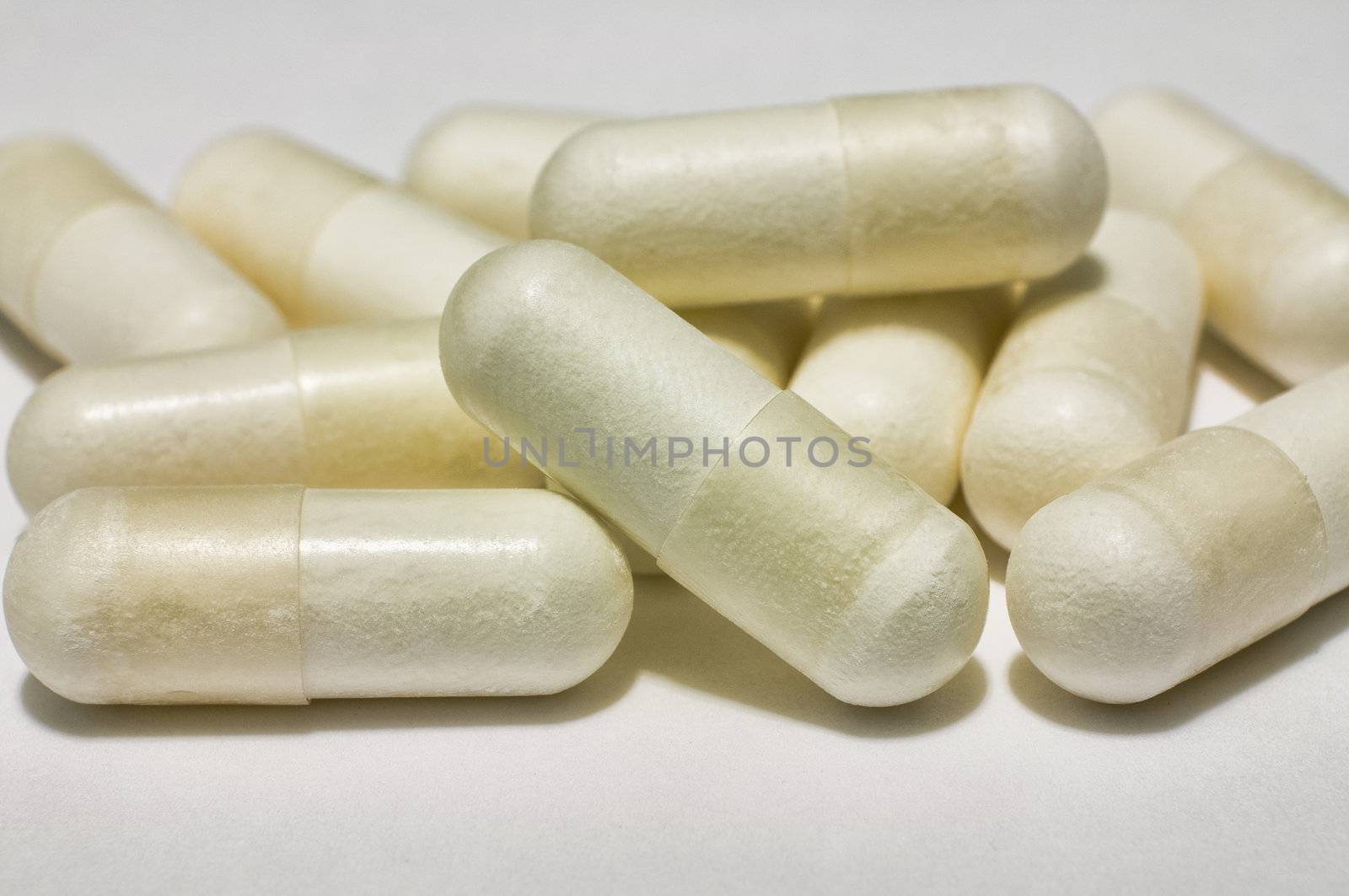 Bunch of capsules of medicine on white by Shane9