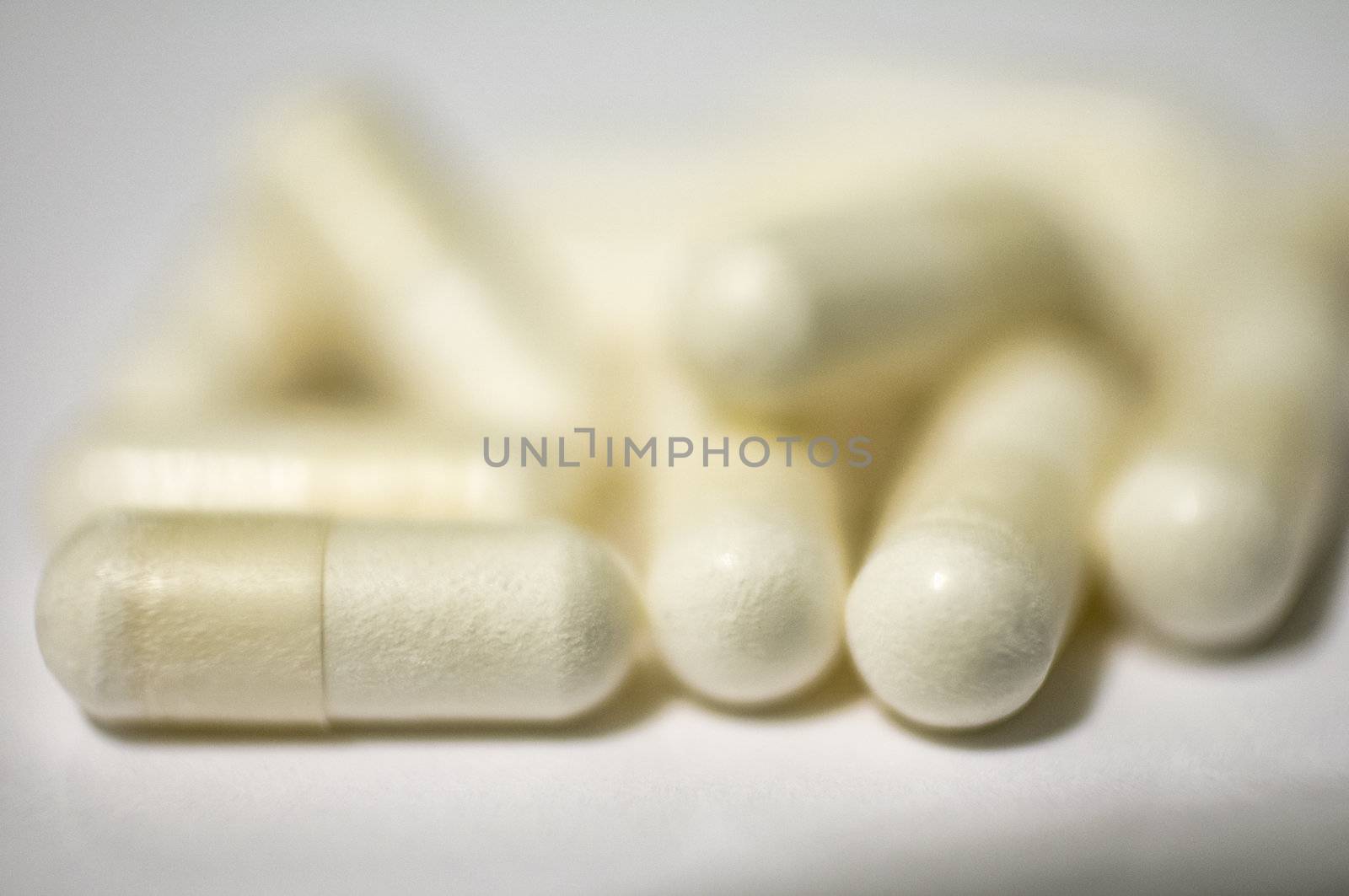 Bunch of capsules of medicine on white by Shane9