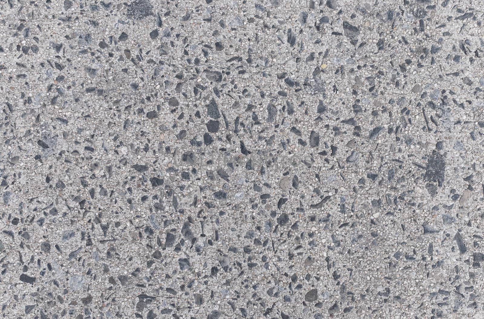 Gray concrete floor with dark stones background