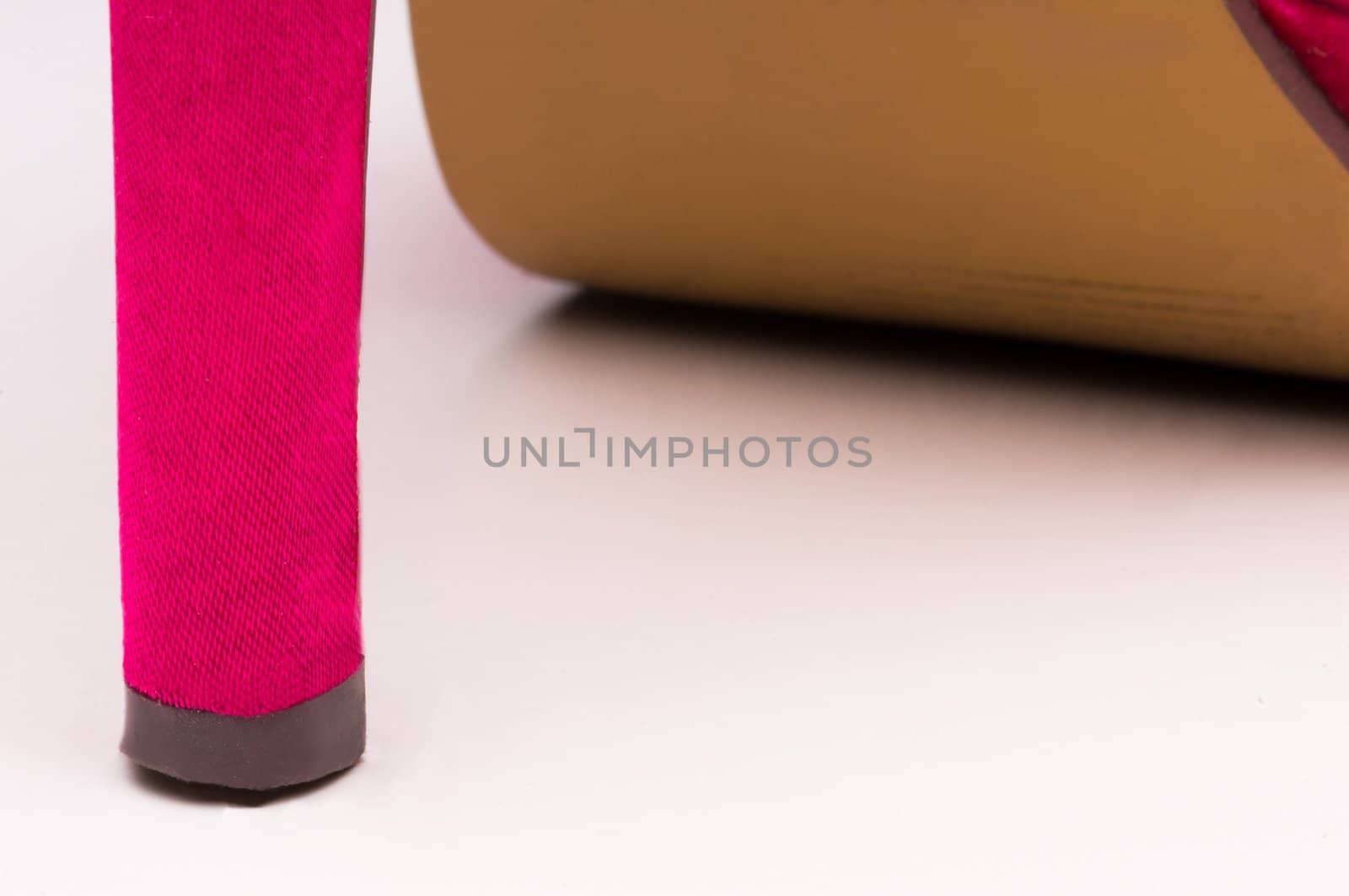 Close up of pink high heel on white background.