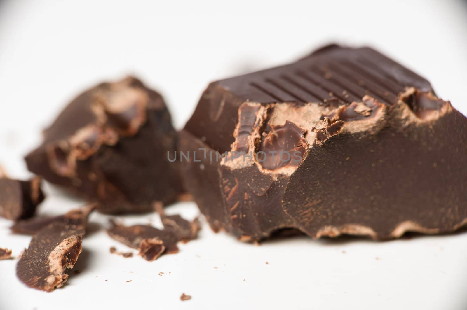 Macro shot of dark chocolate pieces on white.