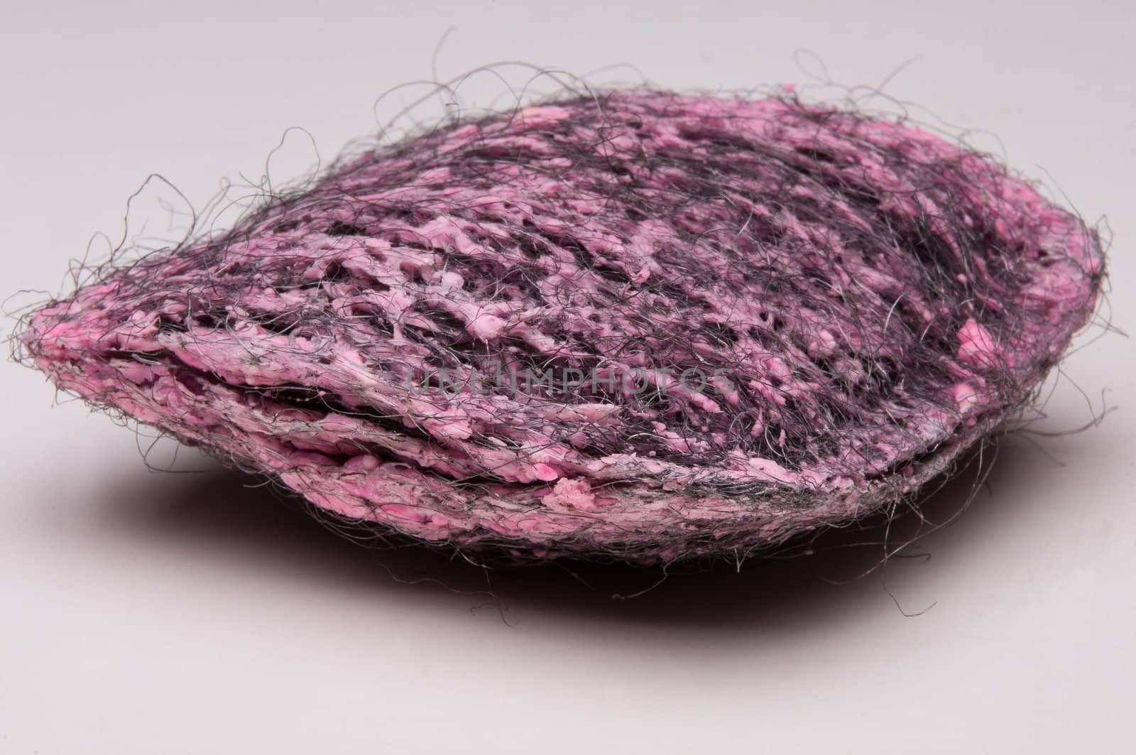 Close up of steel wool with pink soap pad.