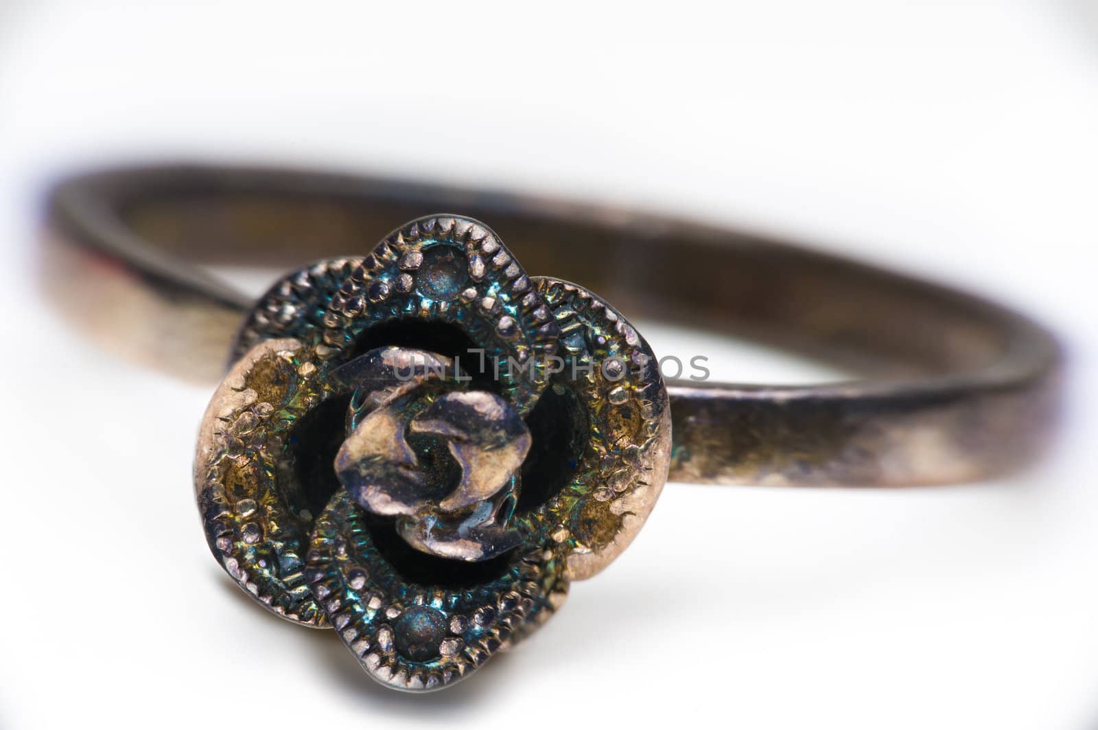 Macro shot of iridescent metal ring on a white background.