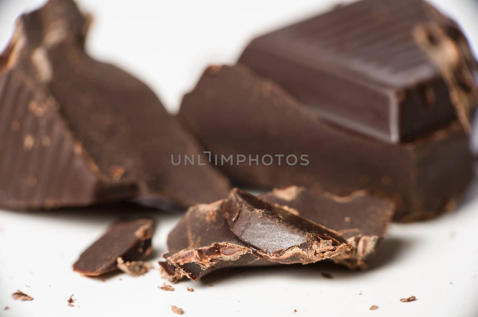 Macro shot of dark chocolate pieces on white.