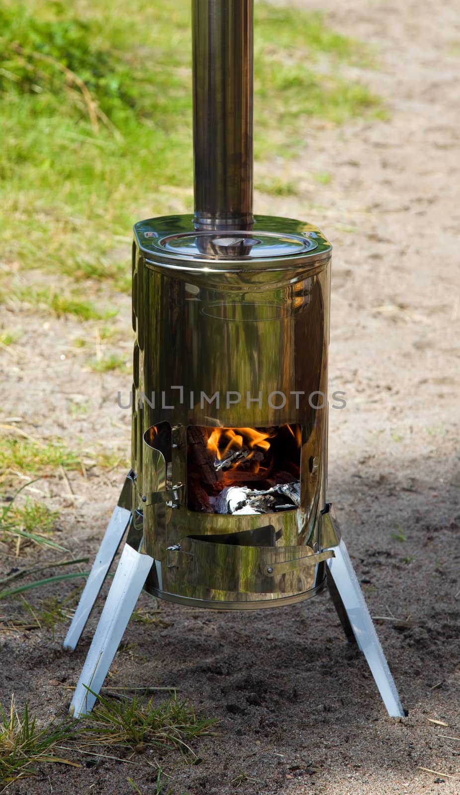 Modular wood stove for the tourist with an open door where the fire is visible